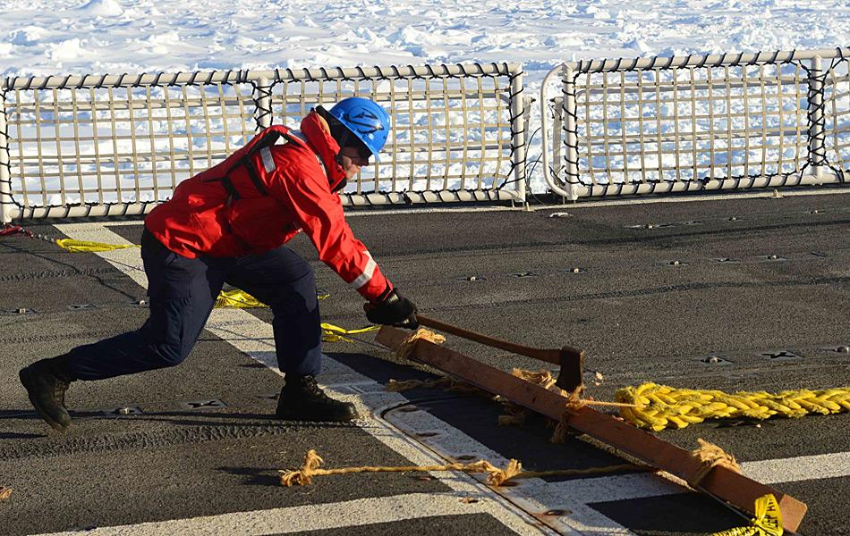 Matrose Patrick O'Grady benutzt eine Axt, um die Schleppleine, an der die «Antarctic Chieftain» hängt, zu durchtrennen. (Foto: US Coast Guard / George Degener)