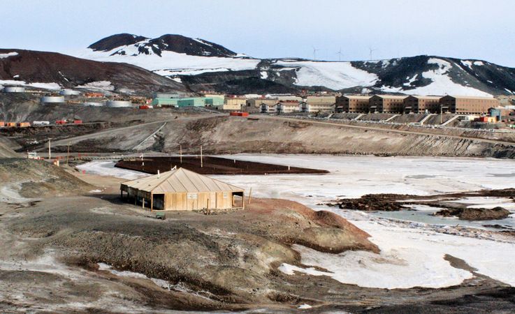 Die Discovery-Hu00fctte auf Ross Island und im Hintergrund die US-amerikanische Basis McMurdo. Von